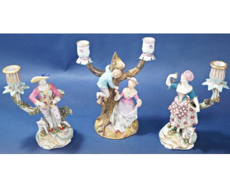 A pair of 18th century continental porcelain candlesticks with male and female characters each with a dog or ewe, with hand p