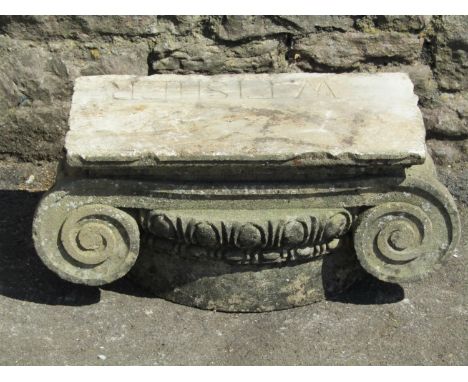 A weathered carved natural stone architectural Doric capital, inscribed 'W Fisher' (51 cm wide x 25 cm high)