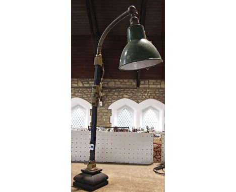 A mid 20th century metal desk lamp with brass adjustable hinges and a flexible pendant and a green metal shade. 