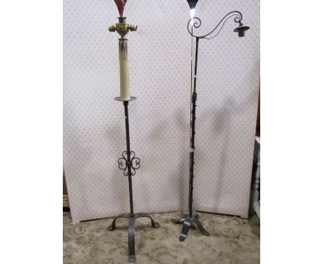 A medieval wrought iron lamp standard on tripod base and a further ironwork lamp standard 