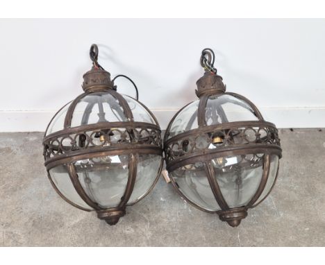 A PAIR SPHERICAL HANGING LANTERN LIGHTS, with glazed bodies and pierced centres, 70cm H. (2)