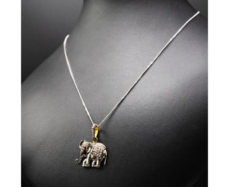 AN ELEPHANT PENDANT IN YELLOW AND WHITE METAL SET WITH A RUBY EYE AND R/C DIAMONDS on a silver chain, boxed, diamonds 0.63ct,
