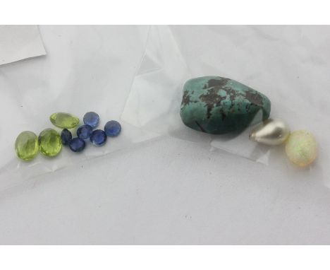 Three unmounted oval cut peridots, six circular cut sapphires, an oval opal, and an opal matrix