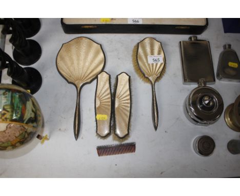 A silver backed and enamel decorated dressing table hand mirror, three brushes and a comb 