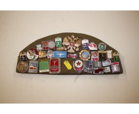 A Cold War Soviet military cap; and a collection of Russian enamel and other badges 