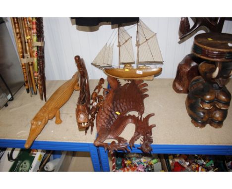 A model ship; a carved dragon ornament; various other carved figures; a crocodile etc