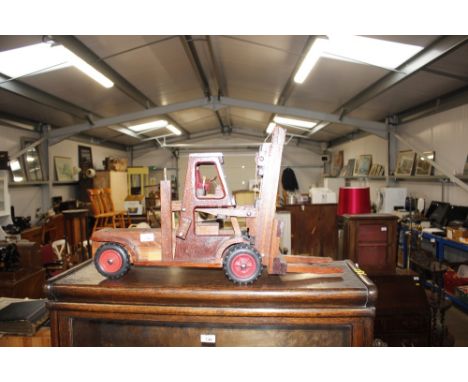 A wooden model of a fork lift