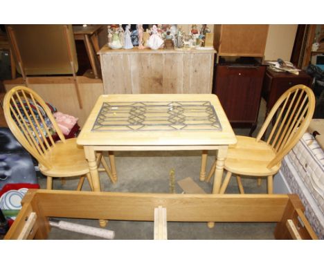 A beech kitchen table and two stick back chairs