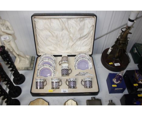 A case containing Aynsley porcelain coffee cans with silver mounts and 5 saucers (incomplete)