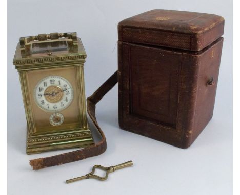 A gilt metal and glass repeating carriage clock, the gilt dial with two white chapter rings to the main dial and subsidiary d