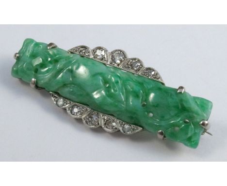 A jade and diamond panel brooch, circa 1933, the carved and pierced rectangular jade with five graduated diamonds above and b