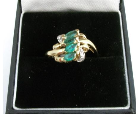 A 9 carat gold four stone emerald ring, with two small brilliant cut diamonds to each shoulder, finger size N, 2.5g gross