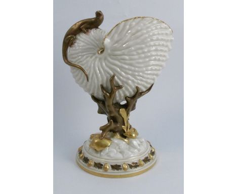 A Royal Worcester gilded ivory centre piece, formed as a nautilus shell mounted on a coral stem, mounted with a lizard, on a 