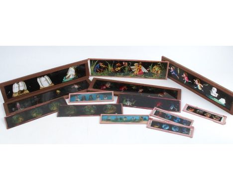 A collection of coloured glass magic lantern slides, to include twelve with wooden frames, three with winding handles, a tin 