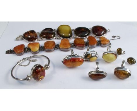 A collection of modern amber jewellery, set in silver and silver coloured metal, comprising a bangle, two bracelets, a pair o