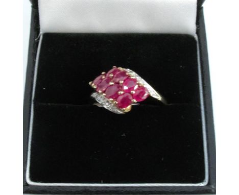 A 9 carat gold eight stone ruby ring, with diamond set shoulders, finger size N 1/2, 2.6g gross