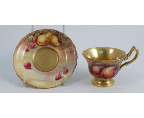 A Royal Worcester cabinet cup and saucer, the exterior of the pedestal cup and the saucer painted with fruit to a mossy backg