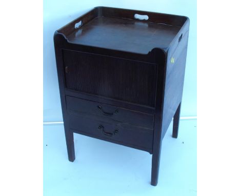 A Georgian mahogany commode, with cut out handles ot the tray top, having a tambour front cupboard, over a drawer, 18ins x 20