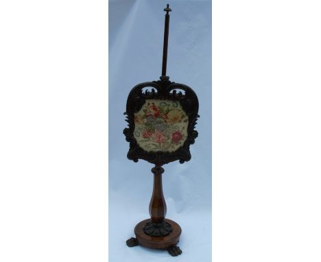 A 19th century rosewood pole screen, with a tapestry panel, raised on a faceted baluster column, on a circular base, with thr