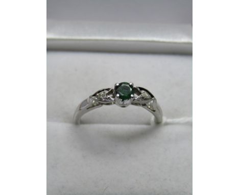 WHITE METAL EMERALD &amp; DIAMOND FREESTONE RING, central emerald set with accent diamonds to each shoulder on white metal sh