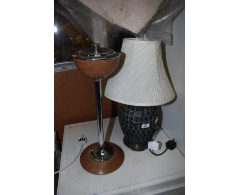 A table lamp and cream shade and an ashtray.