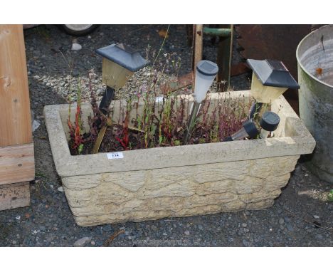 A concrete planter 26" x 11" x 10 1/2" h.