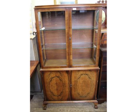 A vintage display cabinet with two door cupboard below