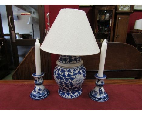 A blue and white ceramic table lamp with a cream linen shade, together with a pair of "Willow" pattern candle holders