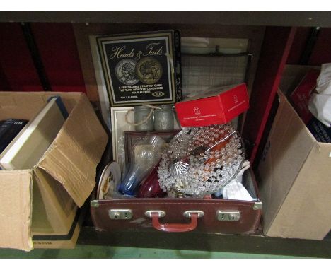 A vintage suitcase containing lamps, ceramics, glassware, etc