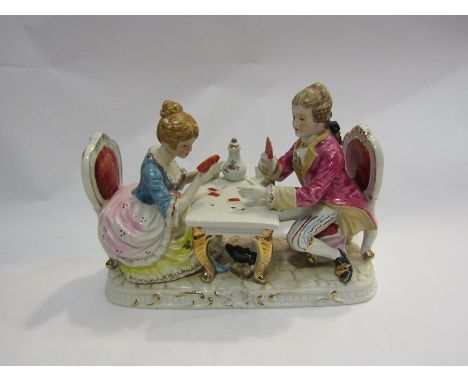 A 19th Century ceramic figural group of couple playing cards, 18.5cm tall