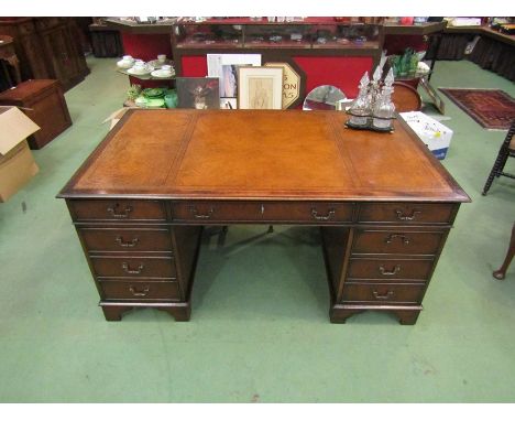 A George III style mahogany twin pedestal desk, the gilt tooled leather writing surface over eight drawers with working locks