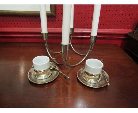 A metal scroll design candelabra together with a pair of espresso coffee cups and saucers