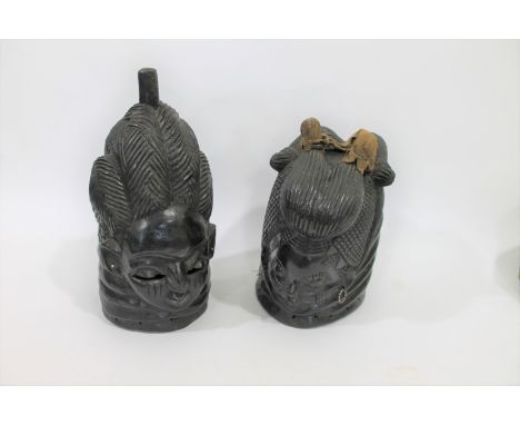 AFRICAN TRIBAL MASKS 2 helmet shaped carved hardwood tribal masks, one with earrings and the other with studs. Both with pier