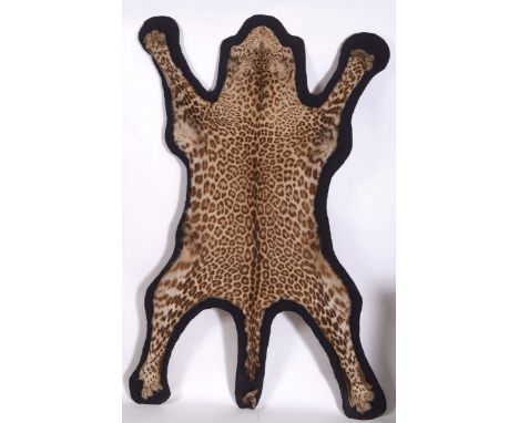 LEOPARD SKIN RUG (Panthera pardus) circa 1930's Leopard skin with a flattened head, mounted on a material backing and on a wo