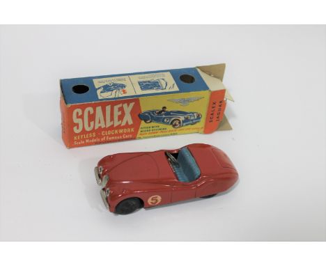 SCALEX JAGUAR XK120 - BOXED a circa 1950's boxed Scalex Jaguar XK120, in red with the number 5. Steering wheel replaced, keyl