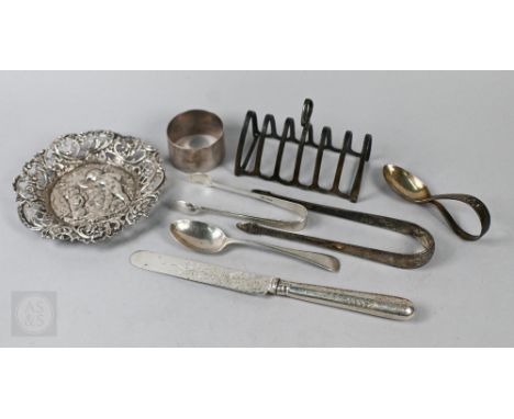An embossed and pierced silver pin dish, London import 1891, a toast rack, napkin ring, a pair of Irish bright-cut sugar tong