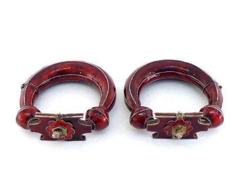 A pair of Indian anklet bangles in white metal with red enamel, the hinged openings with clasps and securing pins. 