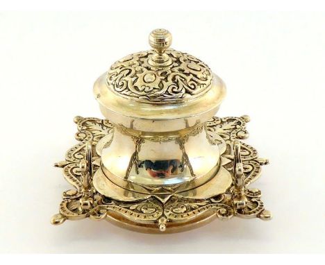 A late Victorian silver inkwell by Gibson & Langman, London, 1896, shaped square base chased with leafage and "S" scrolls and