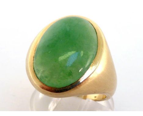 A jade ring, the large jade cabochon 19 x 13mm, rub over set, the shank stamped '14k', finger size Q, 16.1gms CONDITION: shan