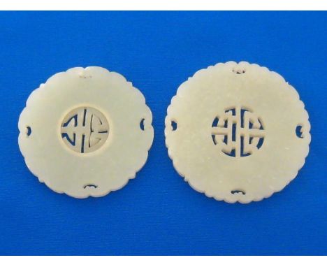 Two openwork Chinese jade circular plaques, each finely carved and pierced on both sides as a “shou” character in the centre 