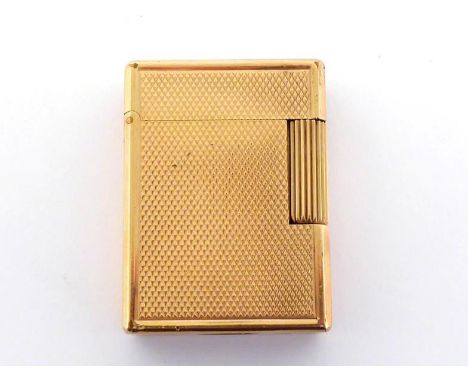 DUPONT, a gilt metal engine turned lighter, together with repair guarantee CONDITION: a few bumps and dents, gilding lost on 