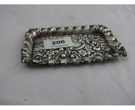 An Edwardian silver trinket tray with embossed floral decoration and raised fluted sides, vacant cartouche, Henry Matthews Bi