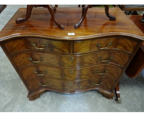 A pretty serpentine front chest on shaped bracket feet, brass drop handles and escutcheons to two short over three graduated 