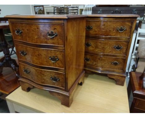 A pair of repro walnut serpentine front string inlaid three drawer bedside cabinets on bracket feet