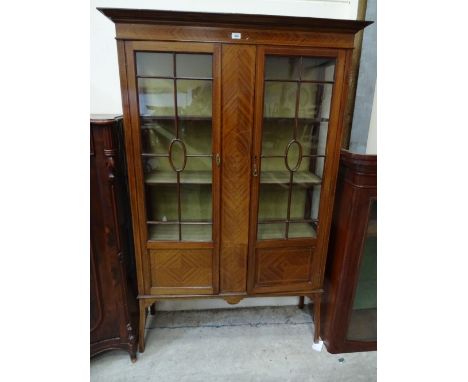 An Edwardian mahogany string inlaid display cabinet with astragal glazed doors to three shelf interior with panelled sections