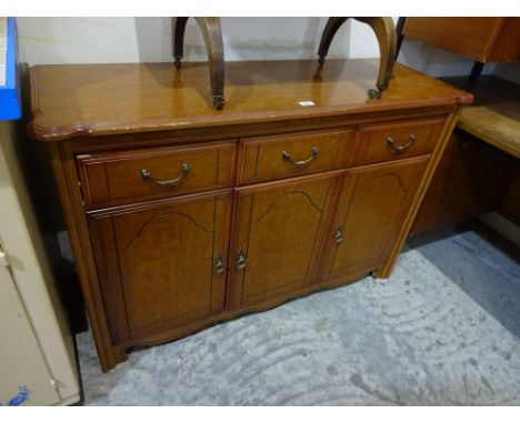 A three drawer sideboard with three cupboards under on bracket feet, 125cm x 43cm x 83cm high