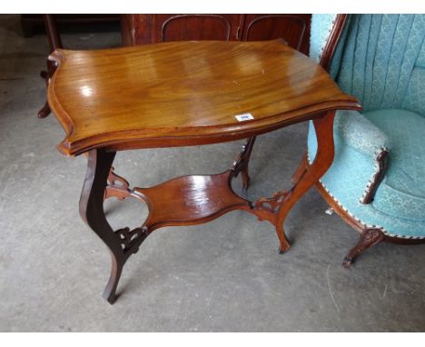 A shaped top mahogany occasional table with stretcher shelf