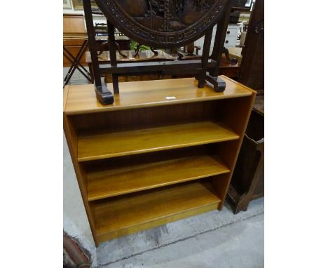 An open three shelf bookcase on plinth base