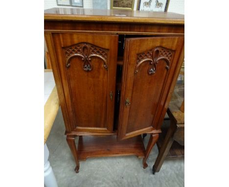 A diminutive cabinet with carved double doors to shelved interior on four extended cabriole legs and stretcher shelf, 65cm x 