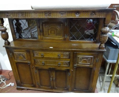 A sideboard with central cupboard flanked by glazed cupboards over drawers and cupboards to base on bracket feet, 141cm x 48c